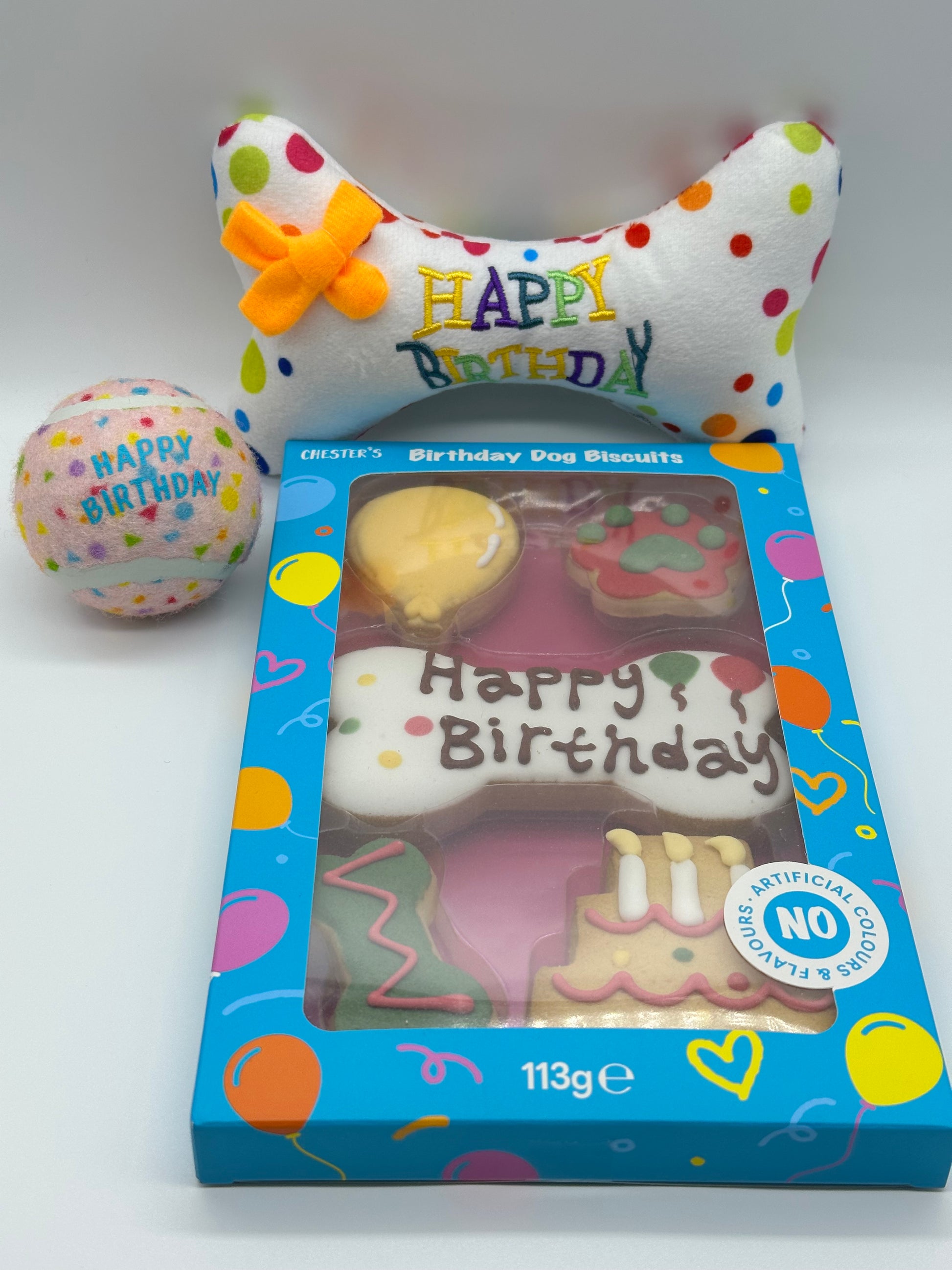 Dog birthday box with birthday biscuits, a soft squeaky bone and a ball