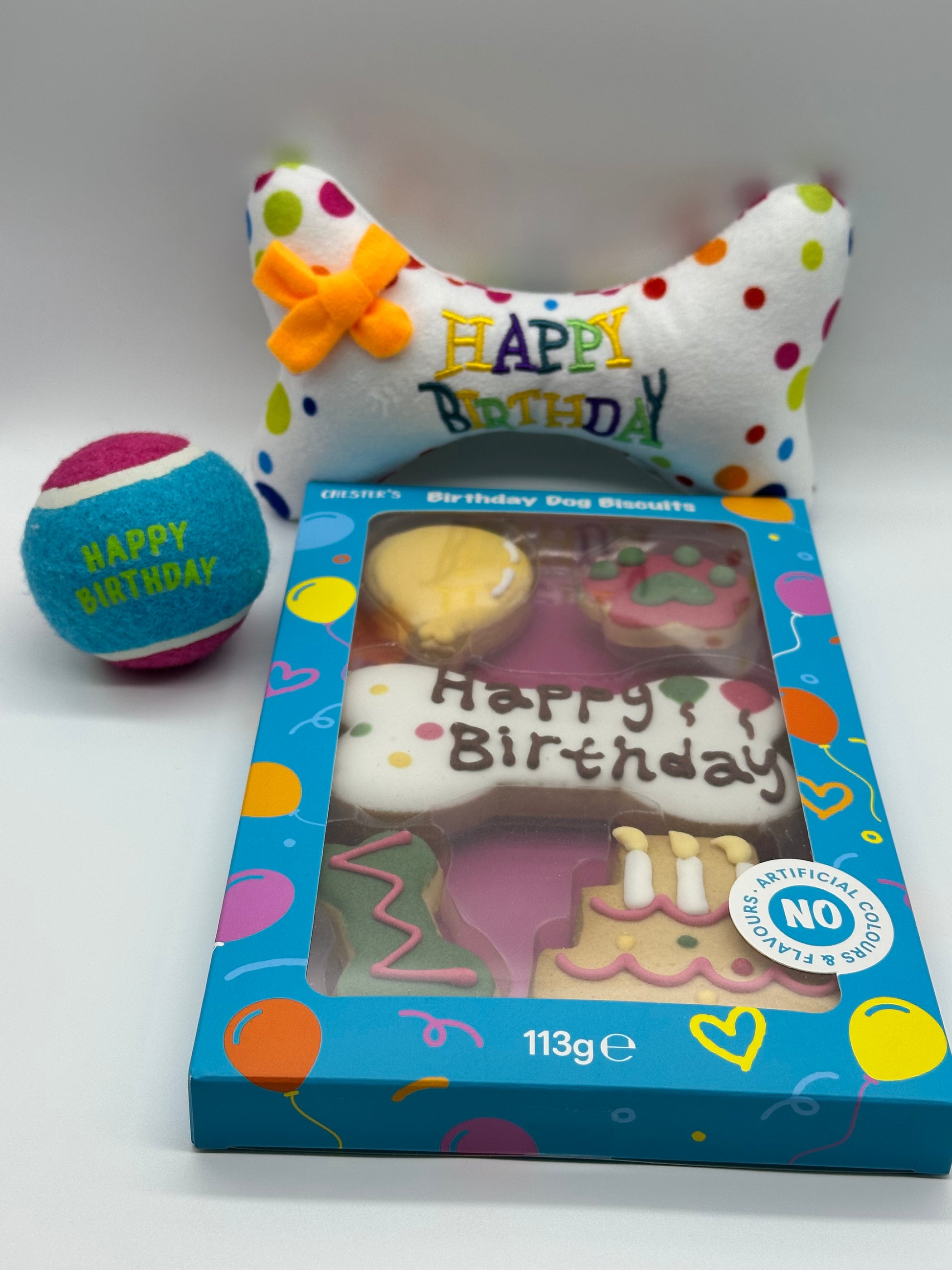 Dog birthday box with birthday biscuits, a soft squeaky bone and a ball
