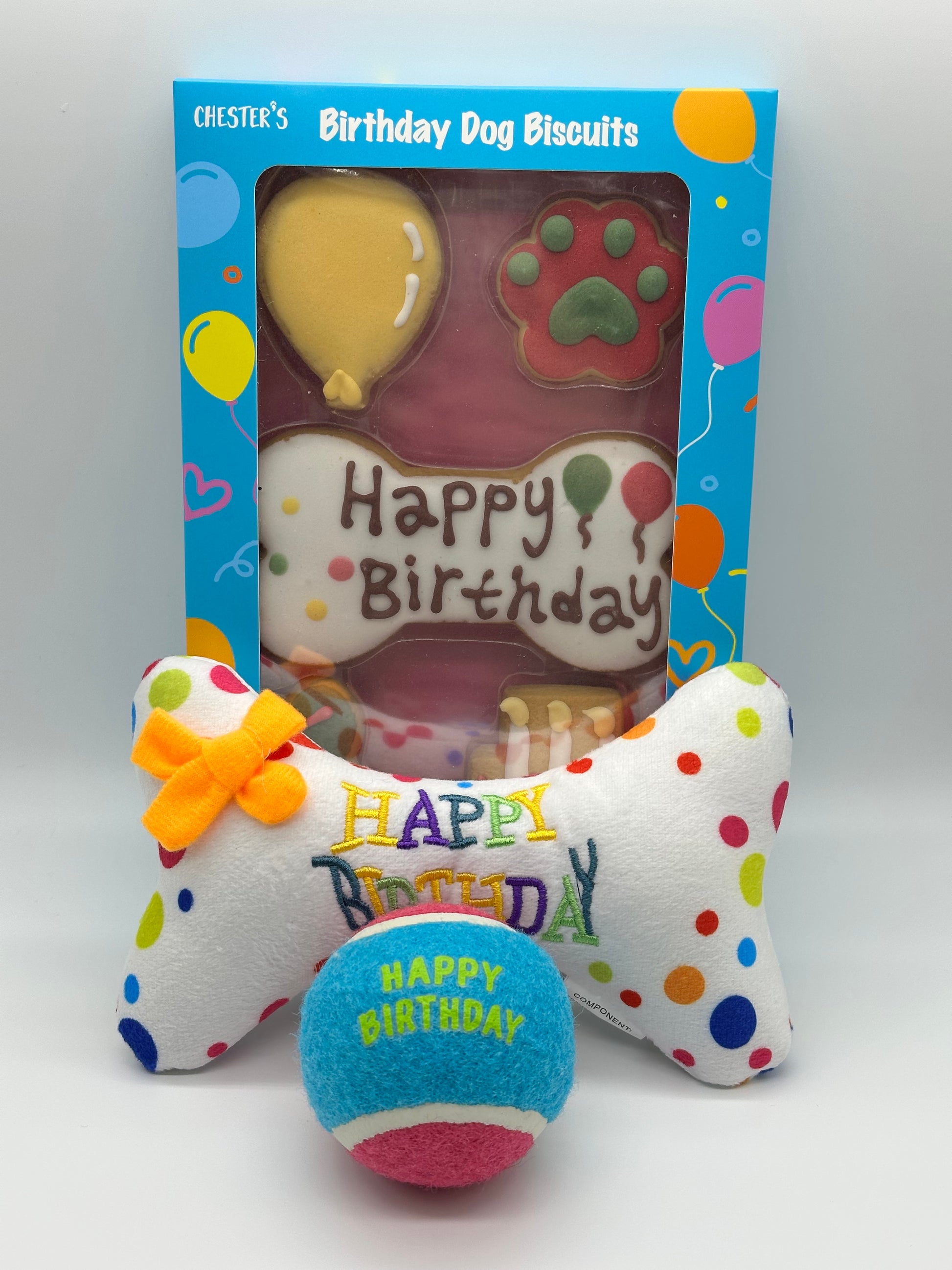 Dog birthday box with birthday biscuits, a soft squeaky bone and a ball